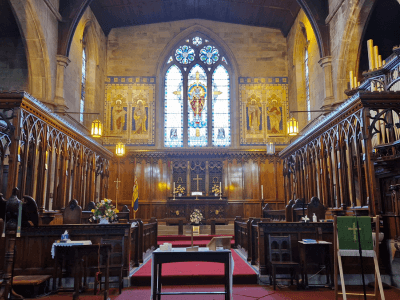 inside St.Georges Church in Tyldesley showing the large stain glass window at the alter