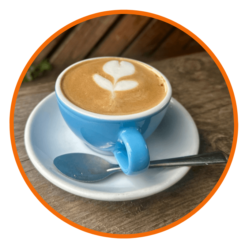 A cappuccino in a blue cup on a wooden table