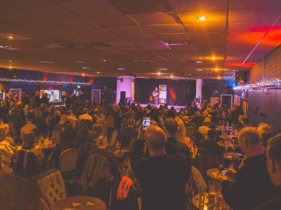 A busy Early Doors Club live music event at Hindley Social Club, with a large seated audience watching performers on stage.